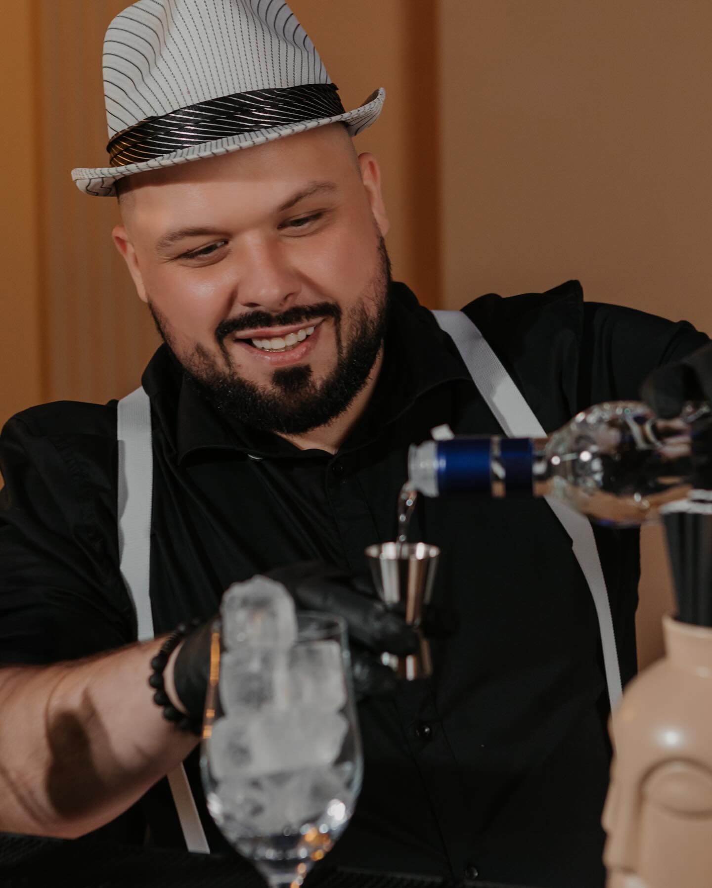 Barman Ryś Events & Fun przygotowuje drink w szkle z lodem