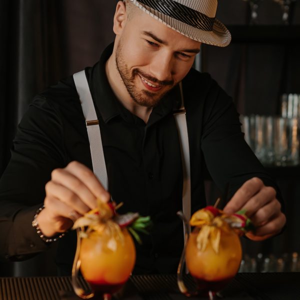 Barman dekoruje dwa koktajle przed podaniem
