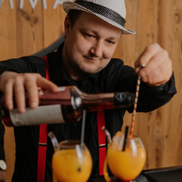 Barman przygotowuje dwa koktajle równocześnie przy barze