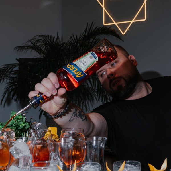 Barman w trakcie dynamicznego przygotowania koktajli przy barze